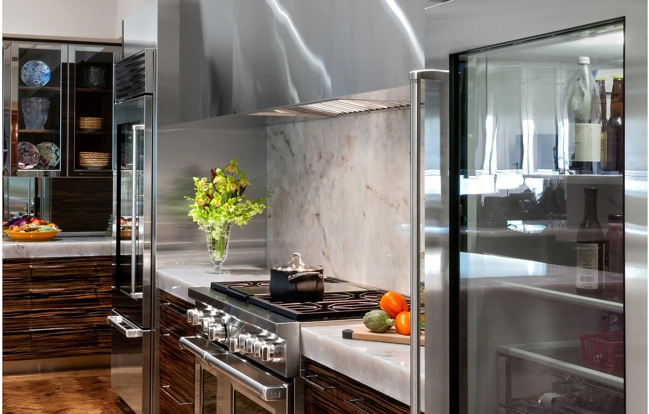 A kitchen with stainless steel appliances and marble counter tops.