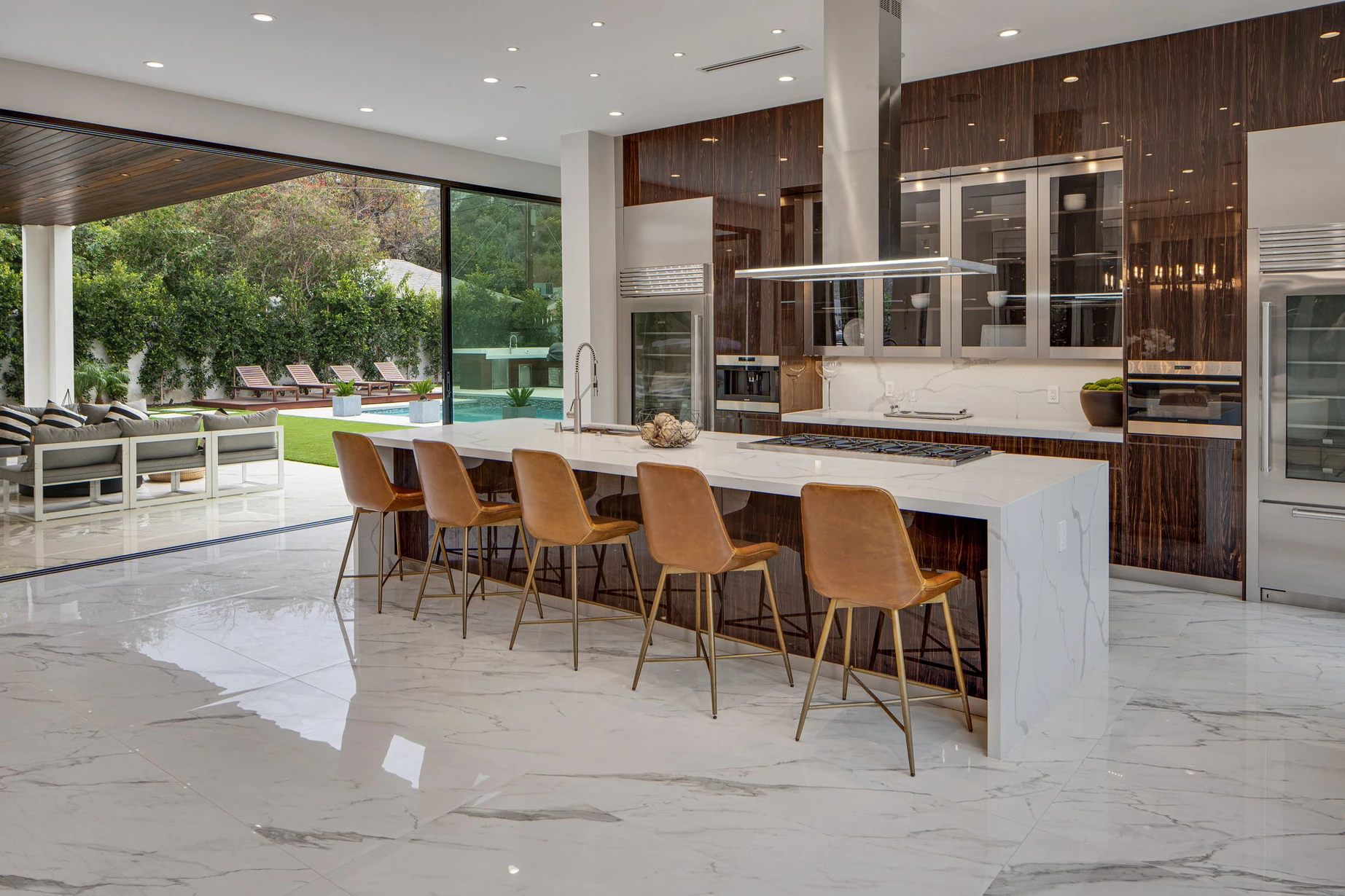 A kitchen with a large counter and lots of chairs.